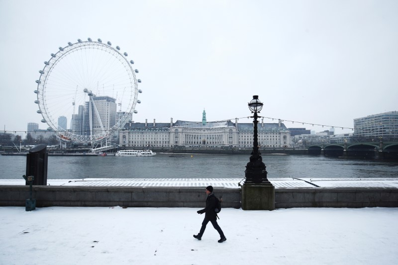 © Reuters. A man walks through the snow on the Embankment in London