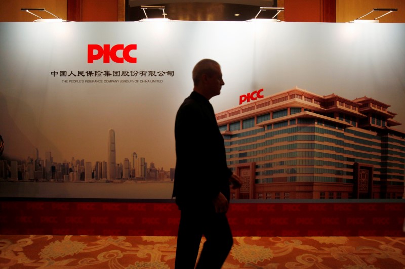 © Reuters. Man walks past backdrop during PICC investors meeting in Hong Kong