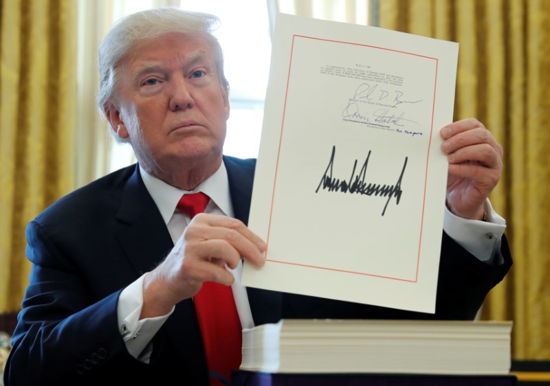 © Reuters. U.S. President Trump displays signature after signing tax bill into law at the White House in Washington