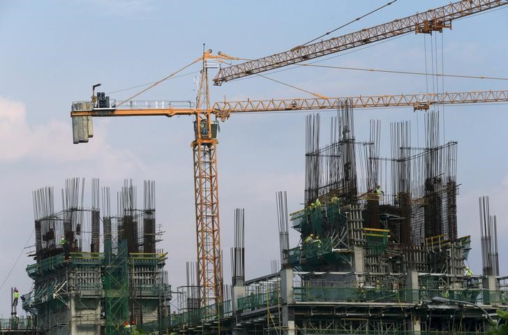 © Reuters. File photo of construction workers building a high rise commercial residential project at a business district in Manila