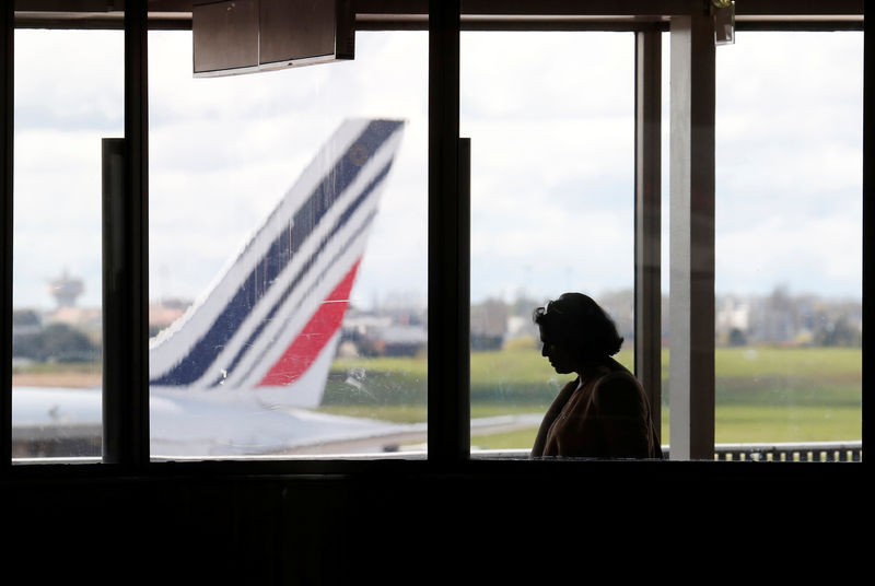 © Reuters. A passenger walks as Air France planes are parked on the tarmac at Orly Airport near Paris as Air France pilots, cabin and ground crews unions call for a strike over salaries