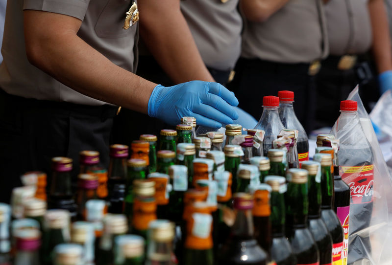 © Reuters. Polícia organiza evidências durante coletiva de imprensa sobre produção e venda de bebida alcóolica adulterada em Jacarta, na Indonésia