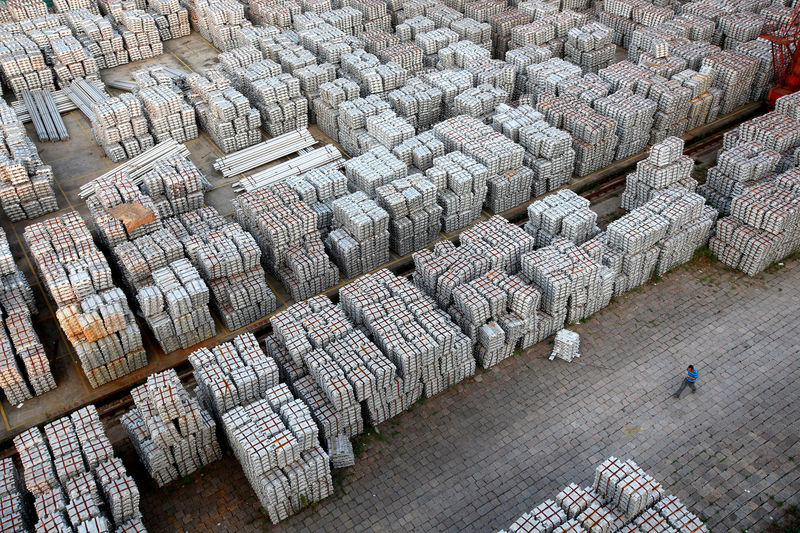 © Reuters. FILE PHOTO: A worker walks through an aluminium ingots depot in Wuxi, Jiangsu province