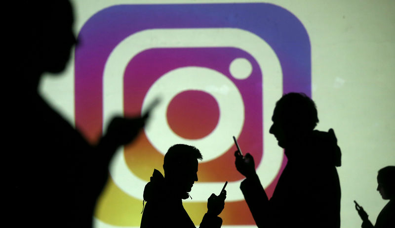 © Reuters. Imagen de archivo de siluetas de usarios de teléfonos móviles frente a una pantalla con el logo de Instagram