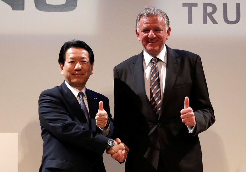 © Reuters. Hino Motors President Yoshio Shimo and Volkswagen Truck & Bus GmbH CEO Andreas Renschler shake hands as they pose for pictures during their joint news conference in Tokyo