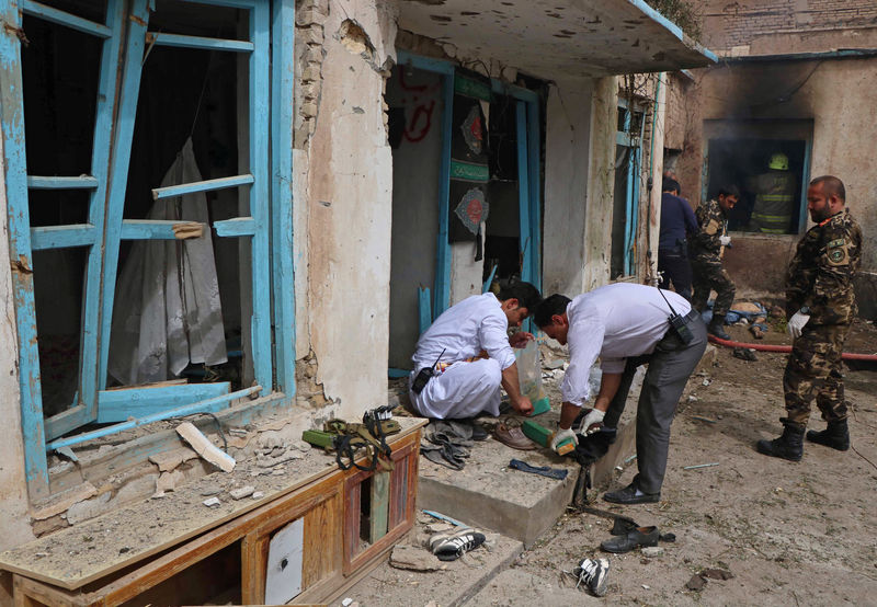 © Reuters. FILE PHOTO: Afghan officials inspect the site of a suicide bomb attack outside a Shi'ite mosque in Herat