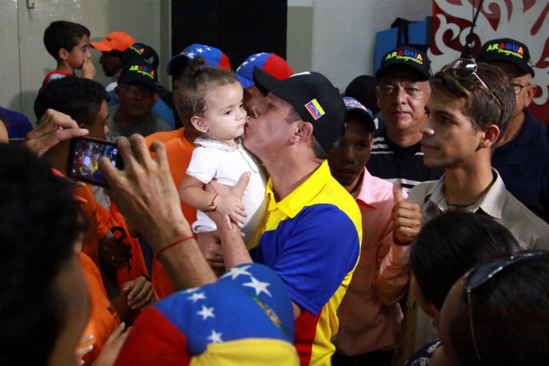 © Reuters. Candidato Henri Falcón beija criança em campanha na cidade de Maracay