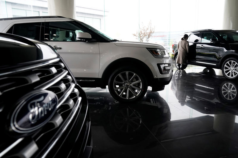 © Reuters. A woman looks at Ford cars at a dealer shop in Shanghai