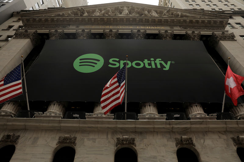 © Reuters. The Spotify logo hangs on the facade of the New York Stock Exchange with U.S. and a Swiss flag as the company lists it's stock with a direct listing in New York