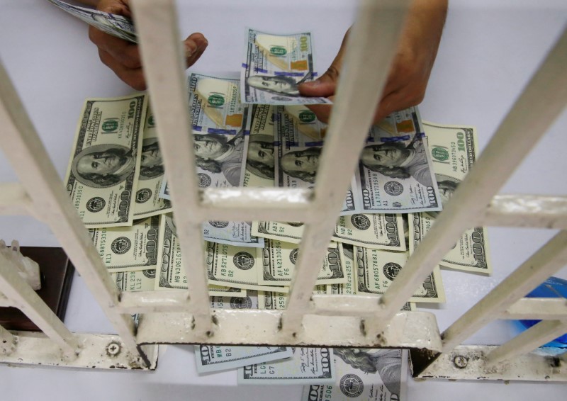 © Reuters. A worker counts U.S. dollar bills inside a money changer in Metro Manila