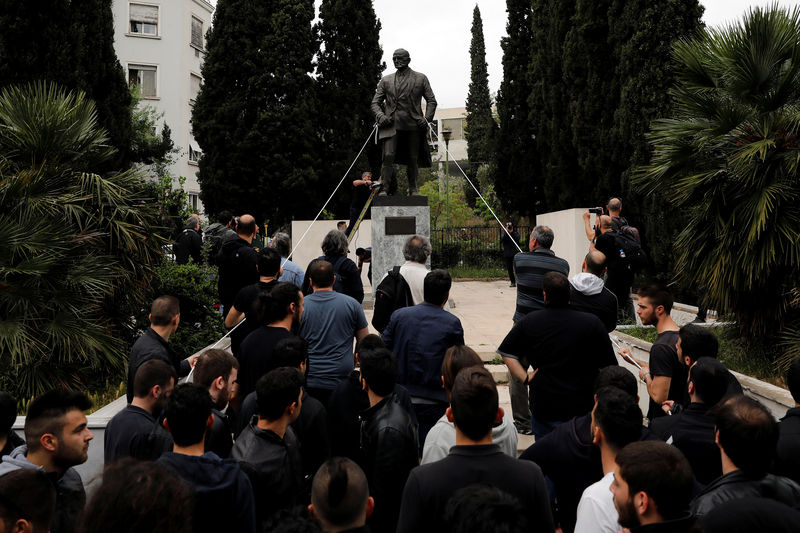 © Reuters. محتجون في أثينا يحاولون إسقاط تمثال أمريكي احتجاجا على ضرب أهداف بسوريا