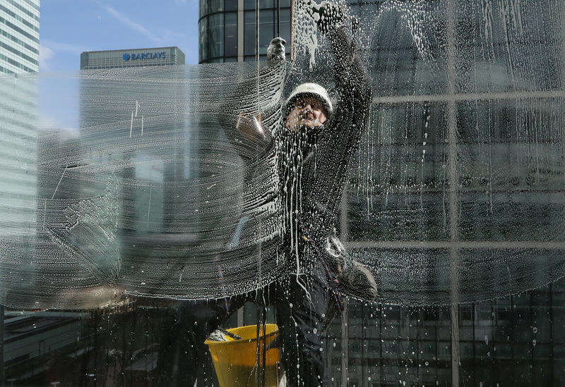 © Reuters. A window cleaner works in the financial district of Canary Wharf in London