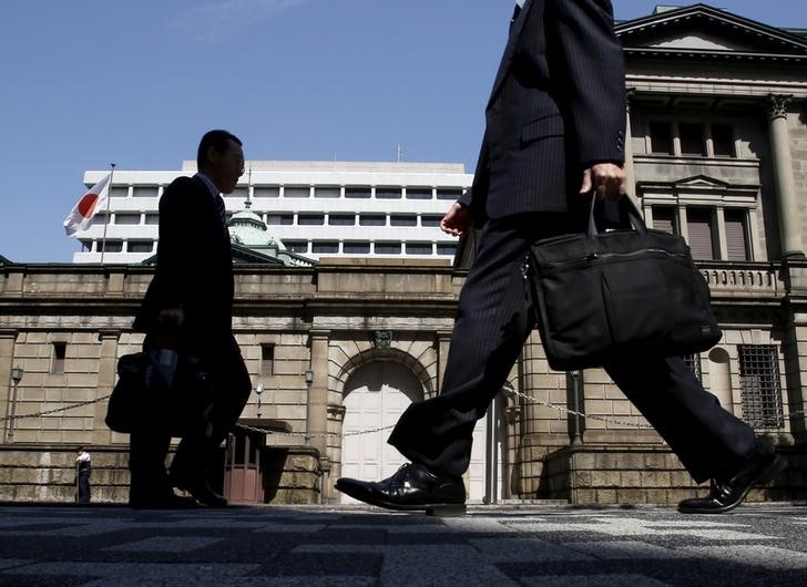 © Reuters. FILE PHOTO - People walk on a street in front of the Bank of Japan headquarters in Tokyo