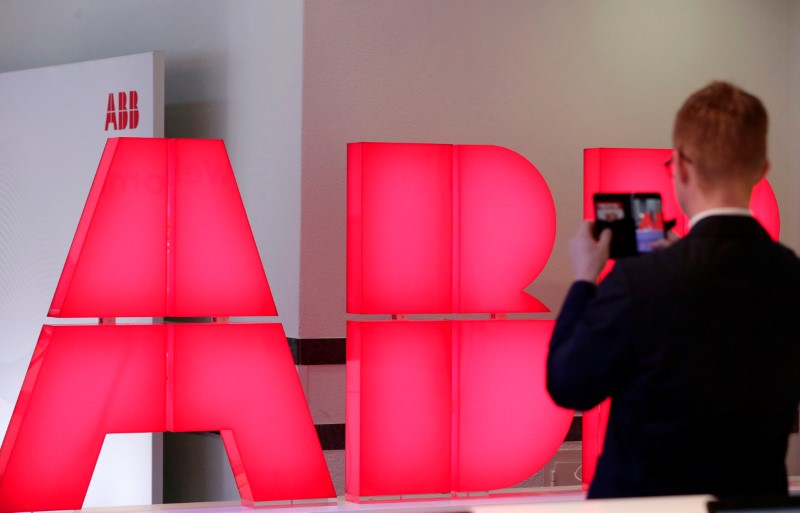 © Reuters. Man takes pictures of logo of Swiss power technology and automation group ABB ahead of a news conference to present full year results in Zurich
