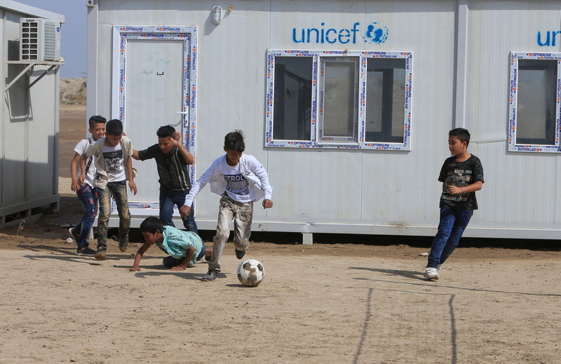 © Reuters. أطفال أقلية الكاولية العراقية يعودون للدراسة بعد انقطاع 14 عاما