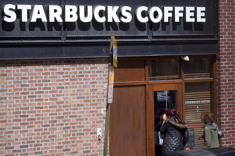 © Reuters. Women peer inside the closed Center City Starbucks, where two black men were arrested, in Philadelphia, Pennsylvania