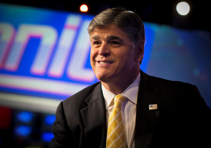 © Reuters. FILE PHOTO - Fox News Channel anchor Sean Hannity poses for photographs as he sits on the set of his show "Hannity" at the Fox News Channel's headquarters in New York City