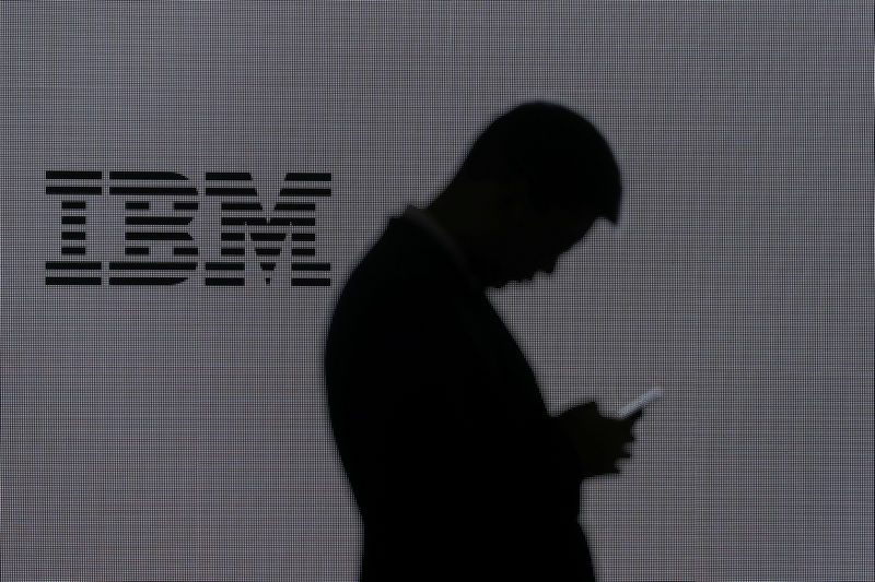 © Reuters. FILE PHOTO: A man checks his mobile phone outside IBM's booth at the Mobile World Congress in Barcelona