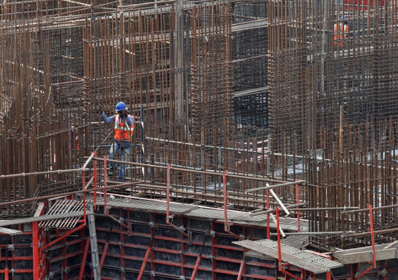 © Reuters. A man works on a construction site of a residential building in Mumbai