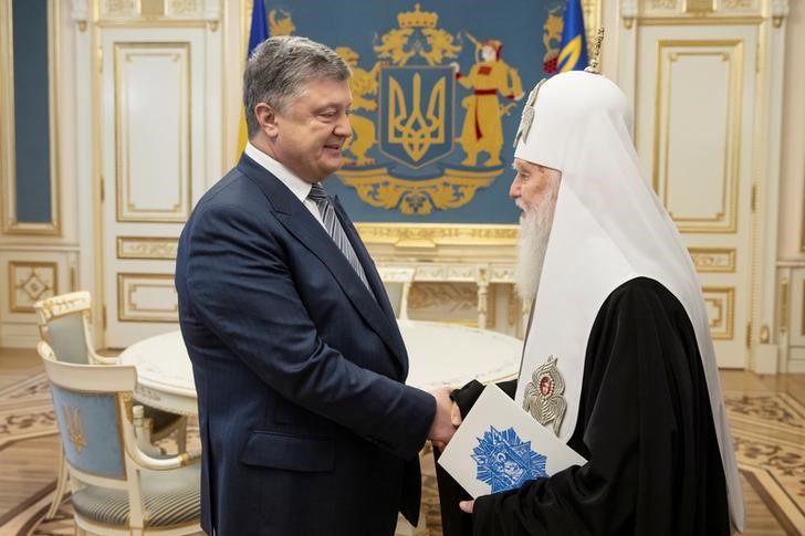 © Reuters. Ukrainian President Petro Poroshenko meets with Patriarch Filaret, head of Ukraine’s Orthodox Church, in Kiev