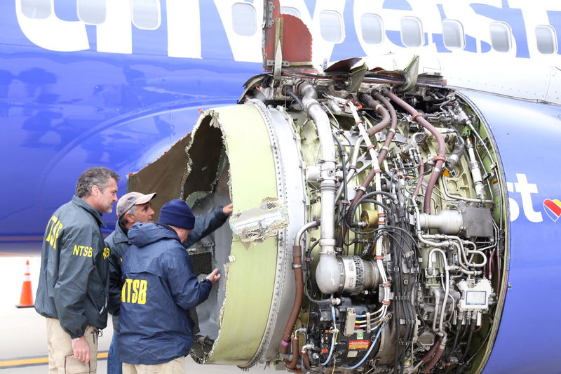 © Reuters. NTSB investigators on scene examining damage to the engine of the Southwest Airlines plane in Philadelphia