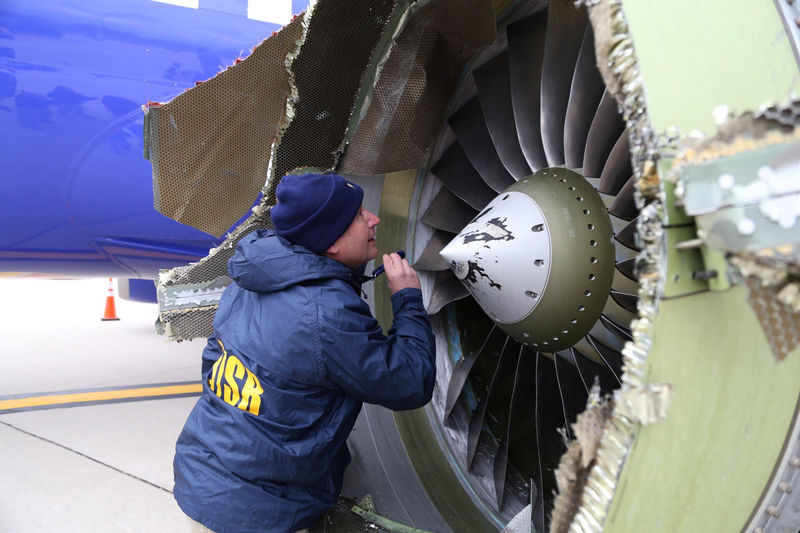 © Reuters. A NTSB investigator on scene examining damage to the engine of the Southwest Airlines plane in Philadelphia