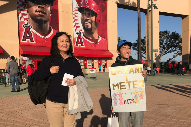 © Reuters. Mickey Misawa of Irvine and Masaaki Nishida of Tokyo come out to root for Shohei Ohtani at a Los Angeles Angels game in Anaheim