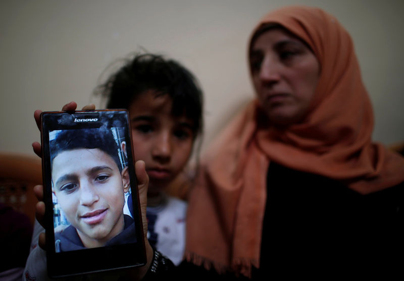 © Reuters. Mother of Palestinian boy who was shot dead by Israeli troops during clashes at the Israel-Gaza border shows her son's photo at her house in Gaza Strip