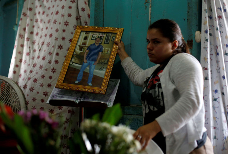 © Reuters. A relative holds a picture of Darwin Manuel Urbina during his funeral in his home in Managua