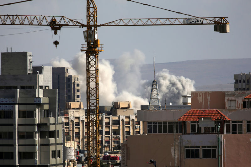 © Reuters. A construction crane is seen as smoke rises from Yarmouk Palestinian camp in Damascus