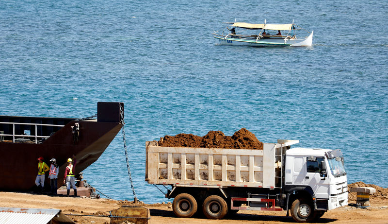 © Reuters. FILE PHOTO: A truck loads rocks and soil containing nickel-ore minerals into a barge in the mining town of Sta Cruz Zambales in northern Philippines