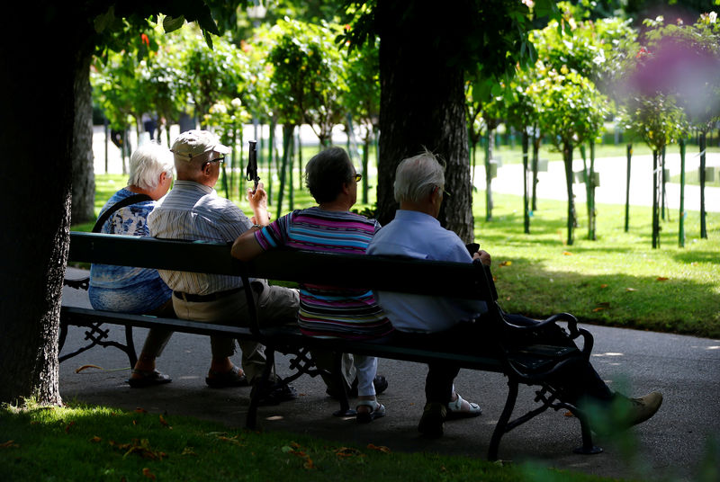 © Reuters. FILE PHOTO: A group of elderly people sit in the shade in a park in Vienna