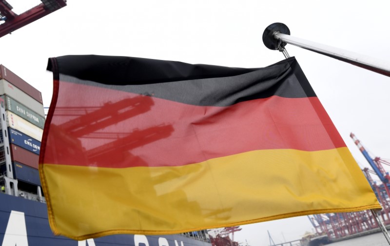 © Reuters. A German flag flutters next to the ships at the loading terminal in the port of Hamburg