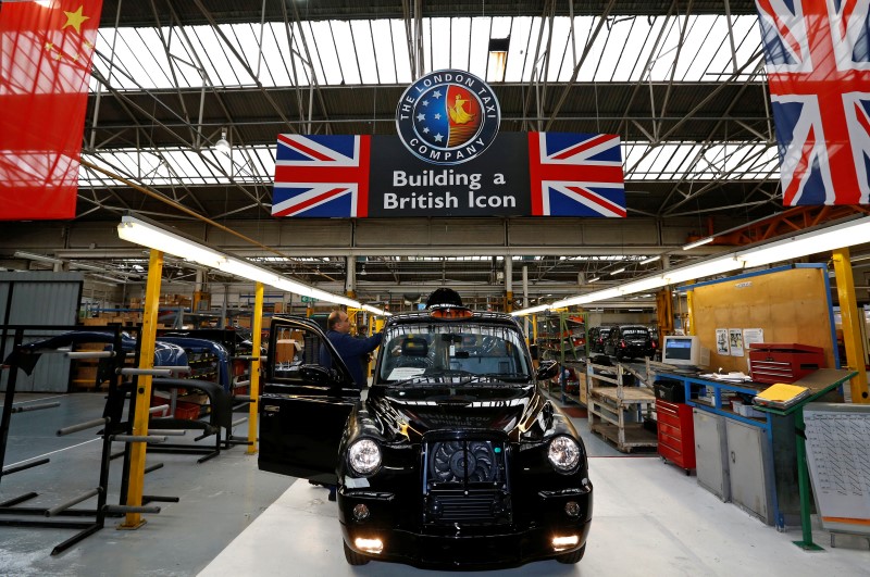 © Reuters. FILE PHOTO: A worker checks a TX4 at the end of the production line at the London Taxi Company in Coventry