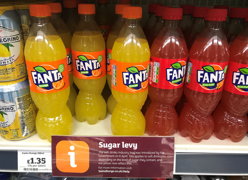 © Reuters. FILE PHOTO - A sign informing shoppers about the UK sugar Levy is seen on a shelf of Fanta soft drinks inside a Sainsbury's supermarket in Manchester.