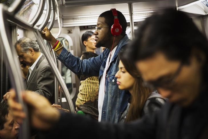 © Reuters. Homem escuta música em fones de ouvido no metrô