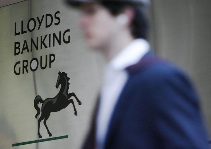 © Reuters. A man passes the head offices of the Lloyds Banking Group in London