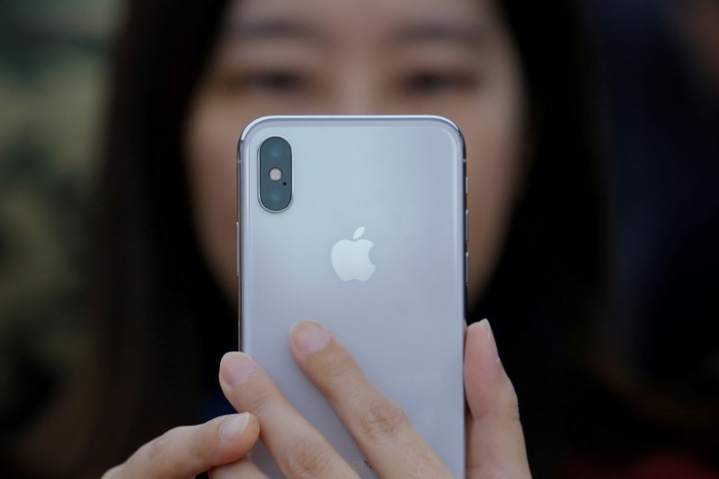 © Reuters. FILE PHOTO: A attendee uses a new iPhone X during a presentation for the media in Beijing