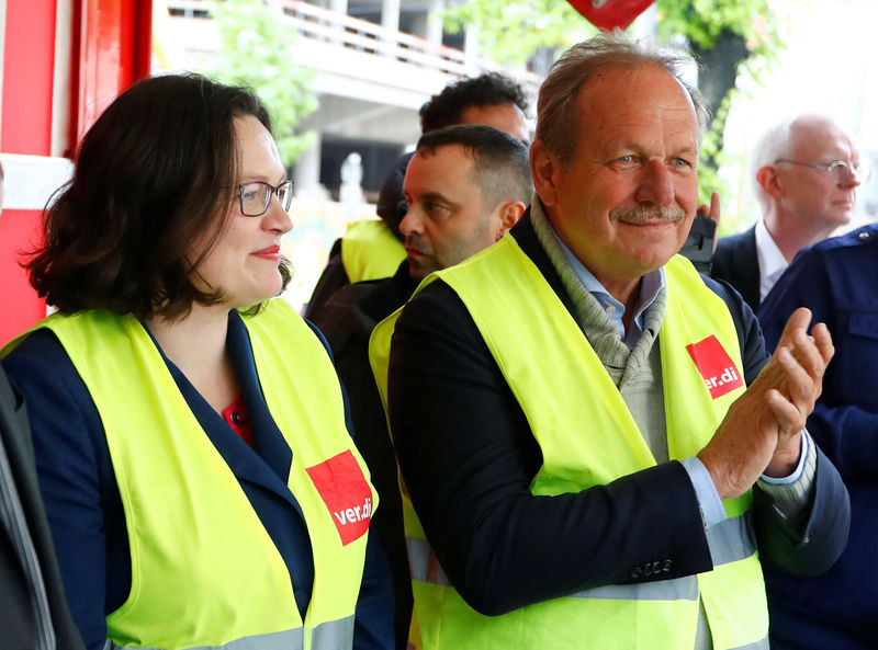 © Reuters. German public sector workers union Verdi leader Frank Bsirske and Andrea Nahles, leader of SPD attend a protest of Amazon worker and activists ahead of the annual Axel Springer award ceremony in Berlin