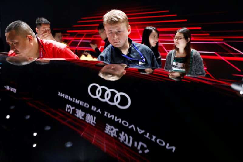 © Reuters. Visitors look at an Audi A8 L 55 TFSI Quattro vehicle displayed during a media preview of the Auto China 2018 motor show in Beijingof the Auto China 2018 motor show in Beijing