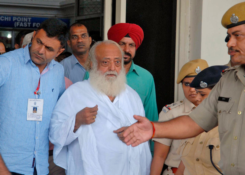 © Reuters. FILE PHOTO: Police escort spiritual leader Bapu outside an airport after his arrest in Jodhpur