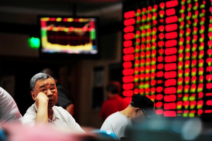 © Reuters. Инвестор сидит возле электронного табло с котировками акций в брокерской фирме в Наньцзине, Китай