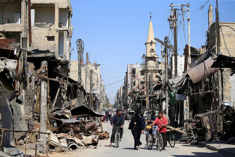 © Reuters. People walk in a street during a media tour in Douma near Damascus