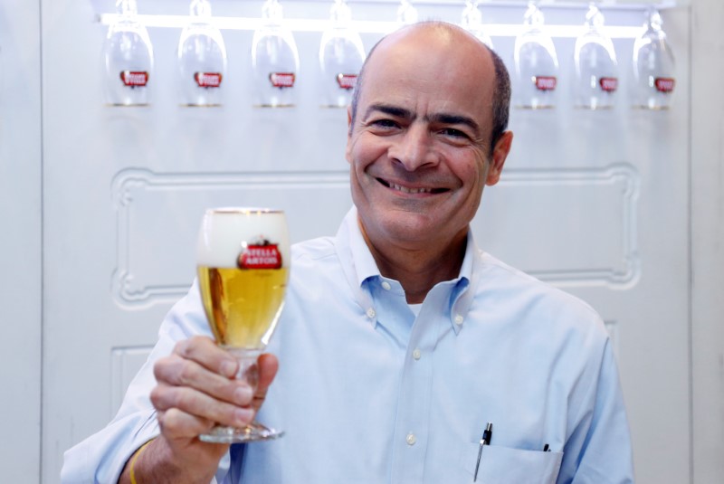 © Reuters. Anheuser-Busch InBev CEO Brito poses with a Stella Artois beer after a news conference in Leuven
