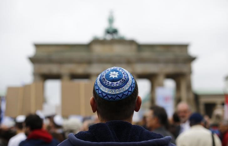 © Reuters. A man wearing a kippah waits for the start of an anti-Semitism demo at Berlin's Brandenburg Gate