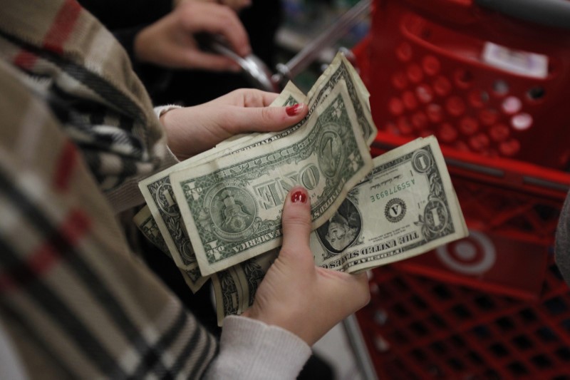 © Reuters. A customer counts her money while waiting in line to check out at a Target store on the shopping day dubbed "Black Friday" in Torrington