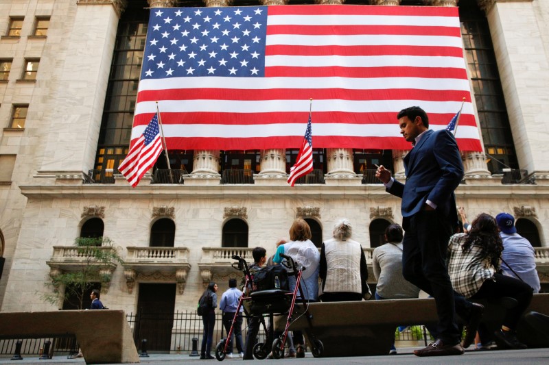 © Reuters. People sit outside the NYSE