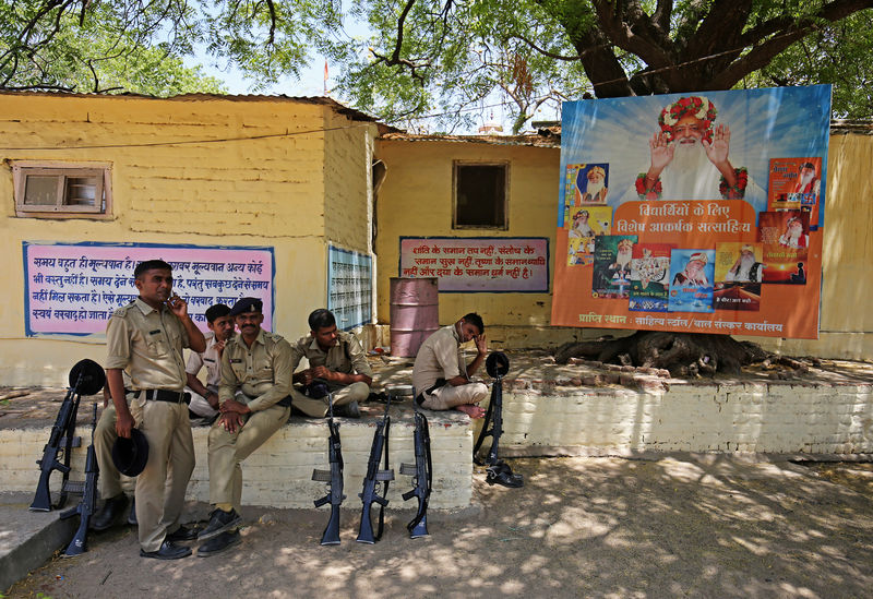 © Reuters. Policiais descansam enquanto fazem guarda  no ashram de Asaram Bapu, em Ahmedabad, Índia