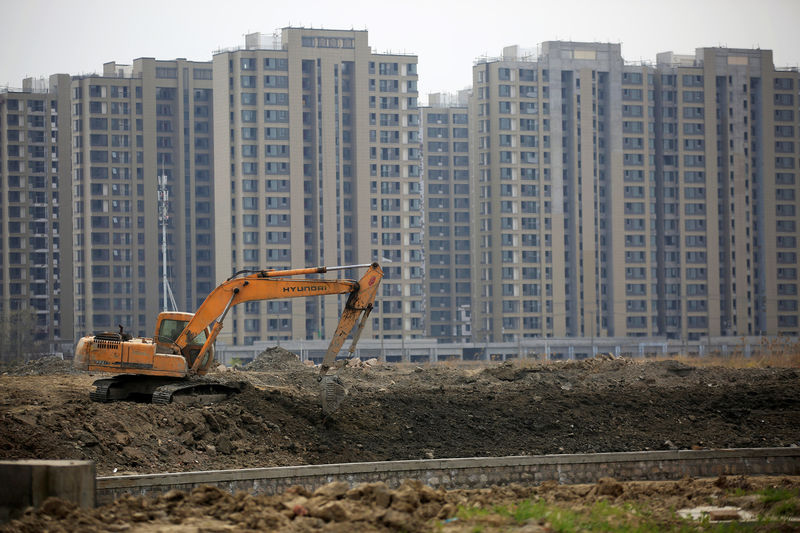 © Reuters. FILE PHOTO: An excavator is seen at a construction site of new residential buildings in Shanghai