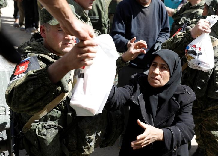 © Reuters. A woman who fled eastern Ghouta receives aid from Russian forces at a shelter in Adra